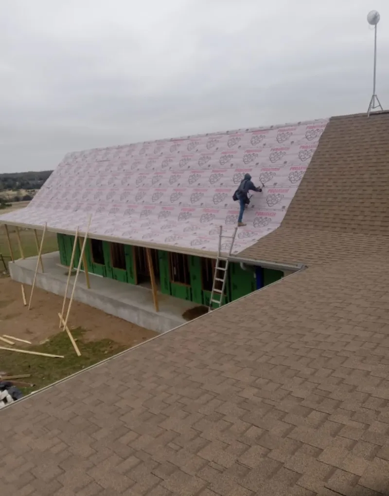 Worker preparing underlayment for a metal roof installation in Benicia